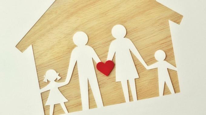 Obitelj papira na drvenoj kući, koja drži srce da predstavlja ljubav, podršku i pomoć ADHD-u