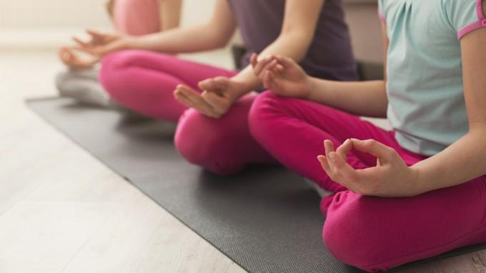 Krupni ruke majke i kćeri rade joga vježbe i istezanje kod kuće. Zdravlje, sport, koncept leasure